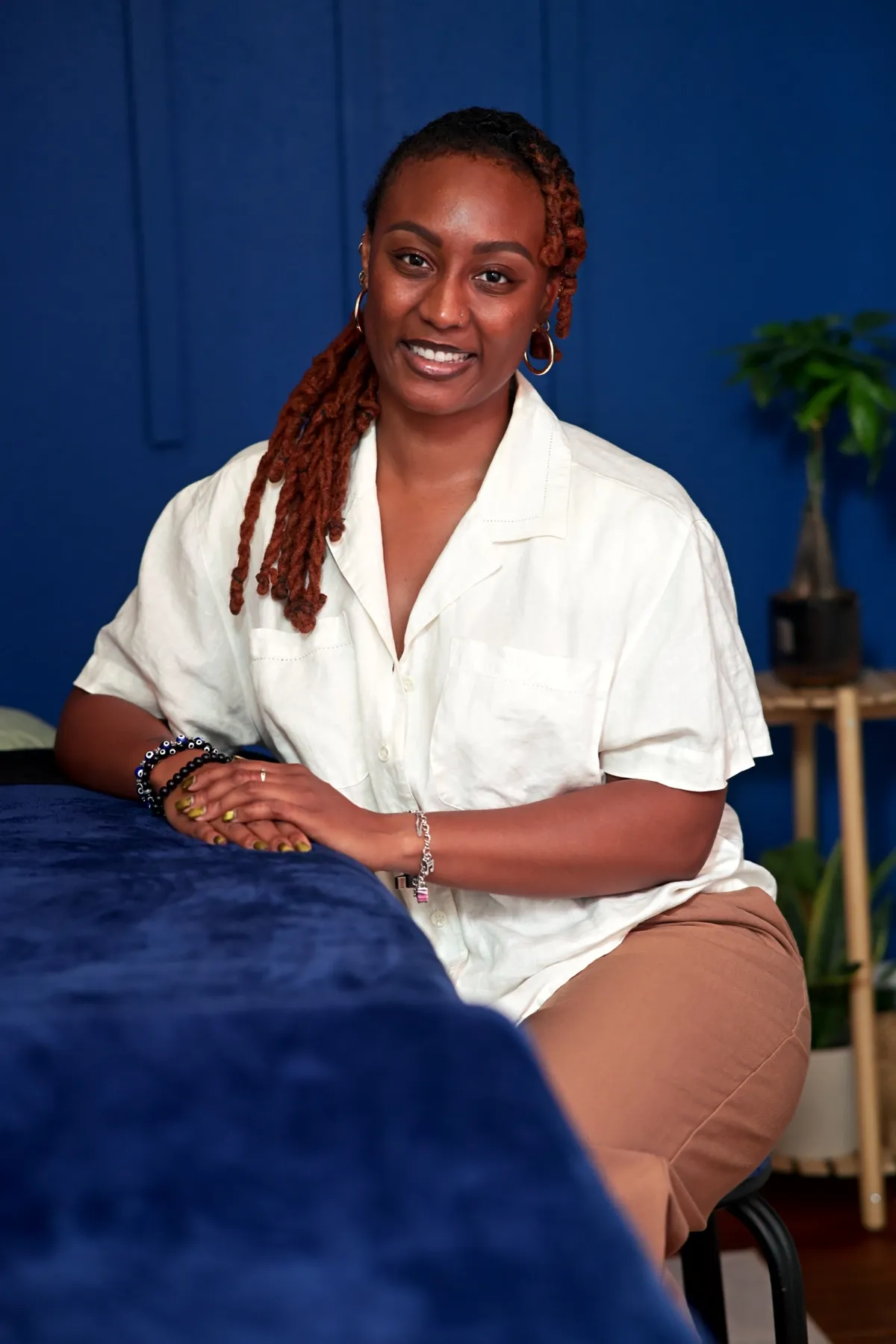 Massage therapist seated in her studio