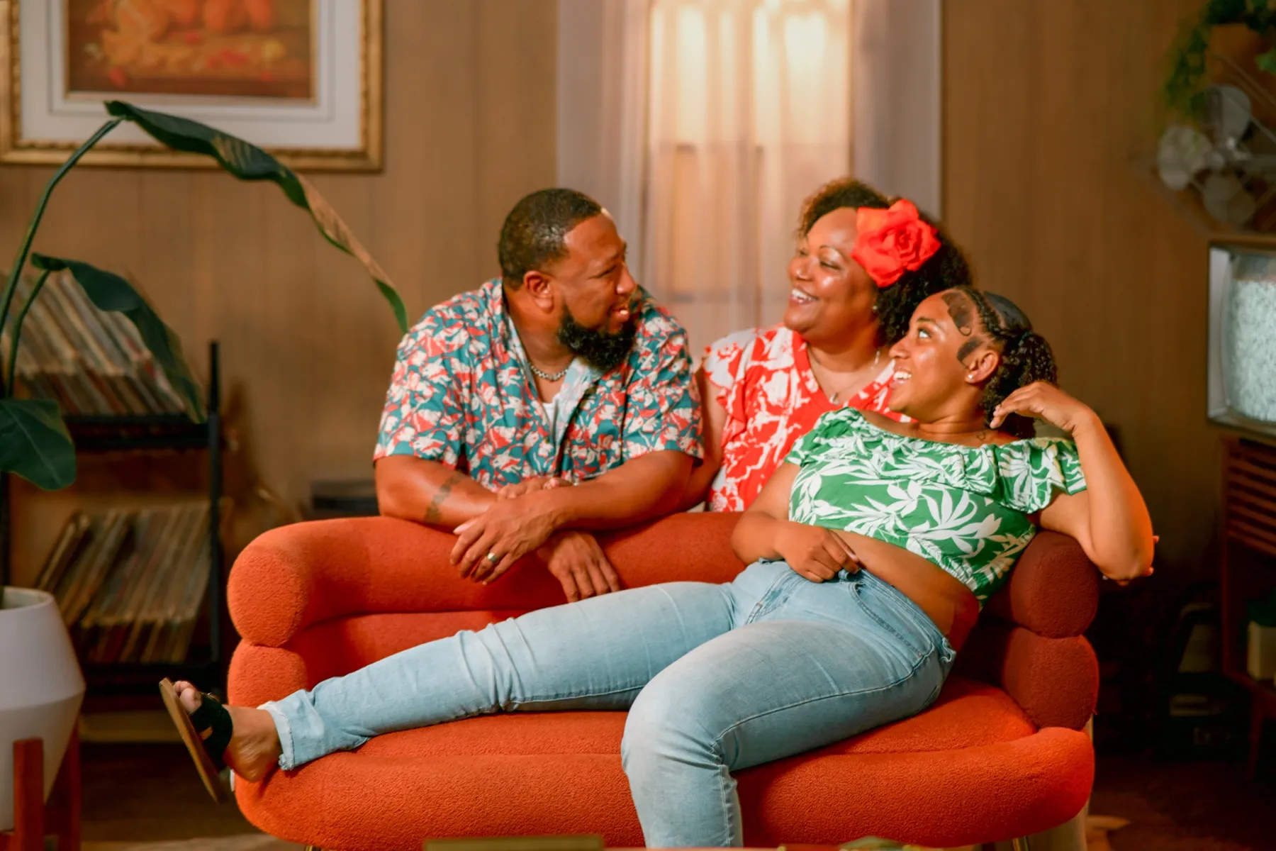 Family laughing together on an orange couch